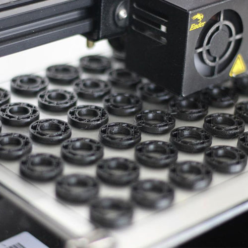 a 3D machine printer with black plastic rings used for linocut presses